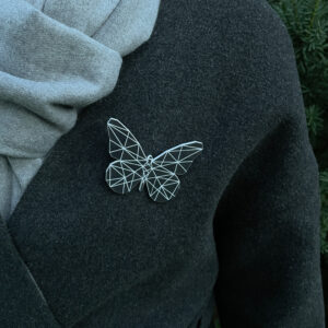 Black butterfly reflecor with geometric pattern on a gray coat