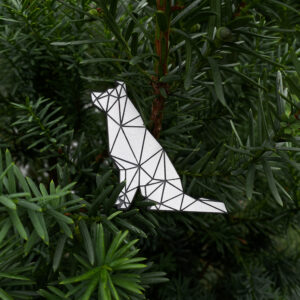 Gray sitting dog reflector with geometric pattern on a green background